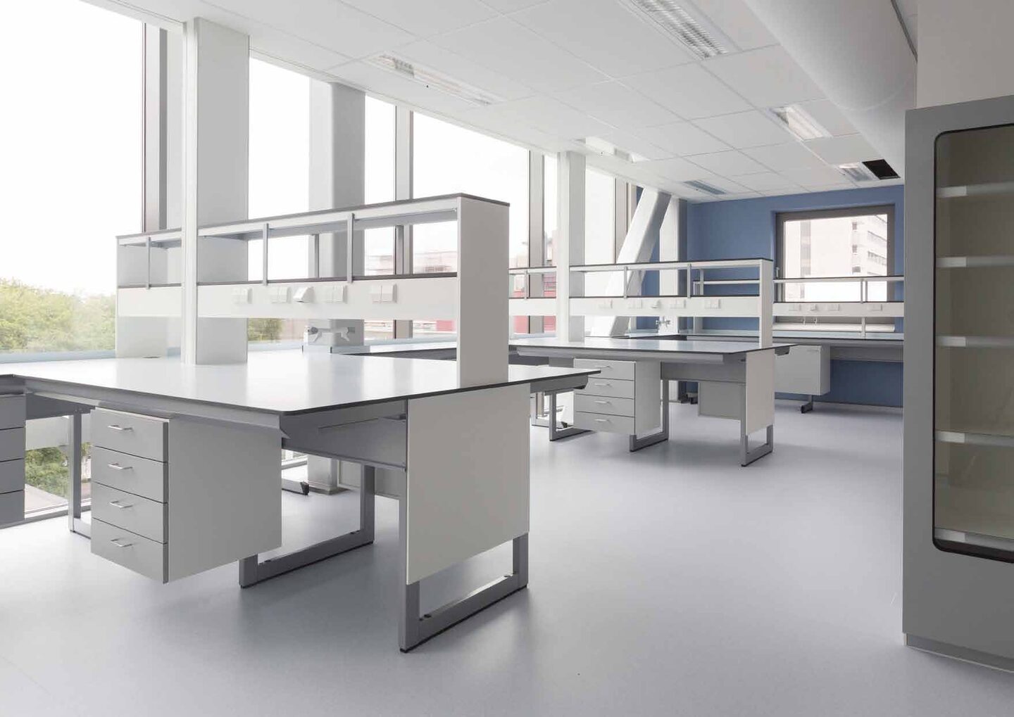 Sanquin laboratorium Amsterdam — grijze stalen werkbanken met blauwe muuraccenten en medische uitrusting